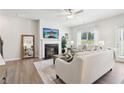 Bright living room featuring a fireplace, hardwood floors, and comfortable seating area at 11841 Rizvan Pl, Covington, GA 30014