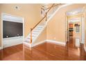 Bright entryway showcasing hardwood floors and a staircase with white railings and wooden banister at 907 Hindman Pl, Mcdonough, GA 30253