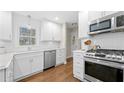 Bright kitchen with white subway tile backsplash, stainless steel appliances and hardwood floors at 922 Grandview Nw Way, Acworth, GA 30101