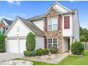 A well-maintained two-story home with stone accents and a manicured lawn under a clear blue sky at 3246 Wellington Sw Walk, Atlanta, GA 30331