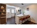 Eat-in kitchen features white cabinets, marble countertops, pendant lighting, and an adjacent wall-mounted display shelf at 4282 Roswell Ne Rd # G1, Atlanta, GA 30342