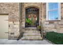 Inviting front entrance featuring a brick facade, double doors with wreaths, and landscaped steps at 4467 Sterling Pointe Nw Dr, Kennesaw, GA 30152