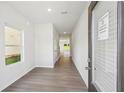 Bright entryway with sleek hardwood flooring, neutral walls, and a clear view into the house at 11840 Rizvan Pl, Covington, GA 30014