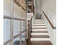 Elegant entryway featuring hardwood stairs with white risers, wooden banisters and a glass paneled front door at 226 Chastain Preserve Ne Ln, Atlanta, GA 30342