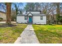 Charming home featuring a new roof, fresh paint, a vibrant blue front door, and a well-manicured lawn at 658 Woods Dr, Atlanta, GA 30318