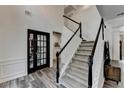 Elegant foyer boasts a staircase with dark wood and white balusters, plus attractive flooring at 245 Davenham Ct, Alpharetta, GA 30005