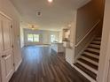 Open floor plan boasts wood flooring and white kitchen with island and granite counters at 8662 Webb Rd, Riverdale, GA 30274