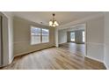 Bright dining room boasting new wood floors, modern chandelier, and a large window that offers plenty of light at 2431 Tolliver Dr, Ellenwood, GA 30294