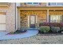 Inviting front porch with stone accents, manicured landscaping, and a charming entranceway at 3129 Arbor Oaks Dr, Snellville, GA 30039
