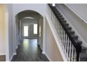 Inviting entryway with elegant archway, stairway with classic white railing, and hardwood flooring at 83 Nyishol Way, Dallas, GA 30157