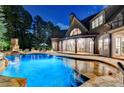 Inviting backyard pool with stone accents and ambient lighting for evening enjoyment at 829 Big Horn Holw, Suwanee, GA 30024