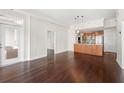 Open-concept living space with hardwood floors, kitchen view, and access to the balcony at 1101 Juniper Ne St # 1504, Atlanta, GA 30309