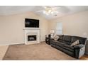 Living room featuring a fireplace with a TV and a comfortable sofa at 60 Cypress Dr, Covington, GA 30016