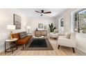 Sunlit living room with modern decor, neutral tones, wood floors, and large windows at 6710 Hidden Brook Trl, Atlanta, GA 30349