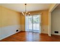 Bright dining area featuring hardwood floors, classic chandelier, and sliding door access to outdoors at 2297 Hylaea Rd, Tucker, GA 30084