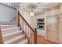 Foyer featuring a staircase, hardwood floors, and a glimpse into the living room with a stone fireplace at 1667 Manhasset Farm Ct, Atlanta, GA 30338