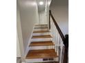 A staircase featuring wood steps, white risers, and a decorative banister at 4510 Burks Rd, Forest Park, GA 30297