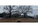Charming home exterior is surrounded by mature trees and lovely landscaping, offering a private setting at 10390 Rivertown Rd, Chattahoochee Hills, GA 30213