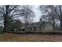 Charming home exterior is surrounded by mature trees and lovely landscaping, offering a private setting at 10390 Rivertown Rd, Chattahoochee Hills, GA 30213