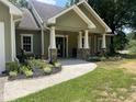 Inviting front porch featuring stone pillars and walkway, perfect for relaxation at 10390 Rivertown Rd, Fairburn, GA 30213