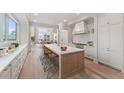 Elegant kitchen featuring a large island with seating, marble countertops, and modern appliances at 1171 Lupo Loop, Chattahoochee Hills, GA 30268