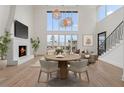 Open-concept living room with a fireplace, modern lighting, and hardwood floors at 1171 Lupo Loop, Chattahoochee Hills, GA 30268