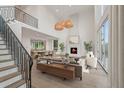 Bright living room featuring a fireplace, high ceilings, and large windows with an adjacent dining area at 1171 Lupo Loop, Chattahoochee Hills, GA 30268