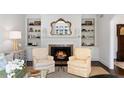 Cozy living room with a fireplace, built-in shelves, and comfortable armchairs at 39 Paces West Nw Dr, Atlanta, GA 30327