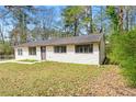 Street view of a cozy, single-story home with mature trees adding natural charm to the property at 7613 Suwannee Ct, Jonesboro, GA 30236