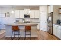 Bright kitchen features a large island, modern pendant lighting, stainless steel appliances, and hardwood floors at 1236 Maston Rd, Auburn, GA 30011