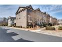 Street view of townhomes with beautiful brick facades and landscaping at 145 Laurel Crest Aly, Johns Creek, GA 30024