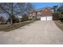 Traditional brick home with a long driveway leading to a two-car garage, surrounded by mature trees at 358 Woodbrook Crst, Canton, GA 30114