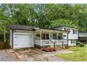 Home with attached garage, landscaped yard, a welcoming front porch, and vibrant flower beds at 2653 Hatfield Se Cir, Atlanta, GA 30316