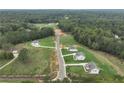 Aerial view of the community, highlighting lush green space, trees, and new construction homes lining the street at 128 Prescott Manor Dr, Canton, GA 30115