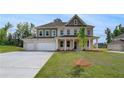 Stunning two-story home featuring a spacious three-car garage, manicured lawn, and a classic design at 165 Haverling Pass, Hampton, GA 30228