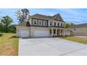 Spacious three-car garage and expansive driveway of this charming two-story home at 165 Haverling Pass, Hampton, GA 30228