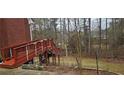 Exterior image showcasing a wooden deck with railing extending from a brick house into a lush backyard at 3715 Millers Pond Way, Snellville, GA 30039