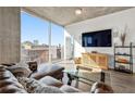 Comfortable living room featuring a leather sofa, wood floors, entertainment center, and city views at 400 W Peachtree Nw St # 2011, Atlanta, GA 30308