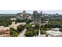 This aerial shot shows the real estate with the skyline in the background and surrounding lush, green landscape at 2660 Peachtree Nw Rd # 11G, Atlanta, GA 30305