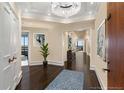 Elegant foyer boasts dark hardwood floors, neutral walls, and a contemporary chandelier for a luxurious entryway at 2660 Peachtree Nw Rd # 11G, Atlanta, GA 30305