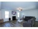 Bright living room featuring a fireplace, ceiling fan, and modern wood-look flooring at 301 Eleanora Xing, Loganville, GA 30052