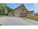 Spacious home showcasing a three-car garage and a wide driveway at 177 Haverling Pass, Hampton, GA 30228