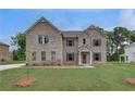 Charming two-story brick home featuring a manicured lawn and a classic design at 177 Haverling Pass, Hampton, GA 30228
