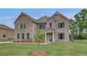 Well-maintained two-story brick home with a cozy front porch and green lawn at 177 Haverling Pass, Hampton, GA 30228