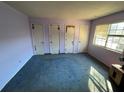 Bedroom with blue carpet, three closets, and natural light at 1411 Brixton Cir, Stone Mountain, GA 30083