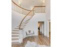 Welcoming foyer with a curved staircase, hardwood floors, and an elegant bench at 3196 Andrews Nw Ct, Atlanta, GA 30305