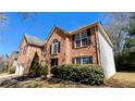 A view of a brick two story home with green bushes in front of the building at 5928 Springfair Run, Lithonia, GA 30038