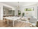 Bright and airy living room with wet bar, hardwood floors, modern lighting, and stylish decor at 1131 Lupo Loop, Chattahoochee Hills, GA 30268