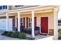 Inviting front porch with comfortable seating, columns, and a red front door at 117 Cottage Nw Walk, Cartersville, GA 30121