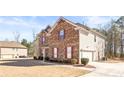 Side view of home showcasing attached two car garage and landscaped yard at 12348 Hillcrest Dr, Hampton, GA 30228